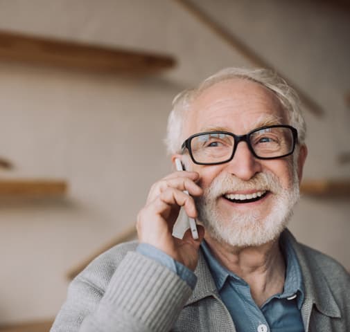 Elderly man happily talking on cell phone